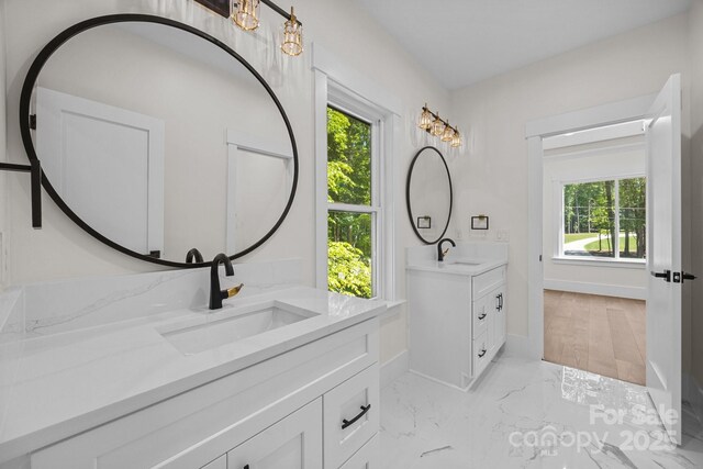 1408 Bloomsberry Ln, Waxhaw, NC 28173 - full bathroom featuring two vanities, healthy amount of natural light, baseboards, and marble finish flooring