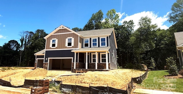 9945 Cask Way, Huntersville, NC 28078 - view of front of property featuring board and batten siding, covered porch, stone siding, and an attached garage