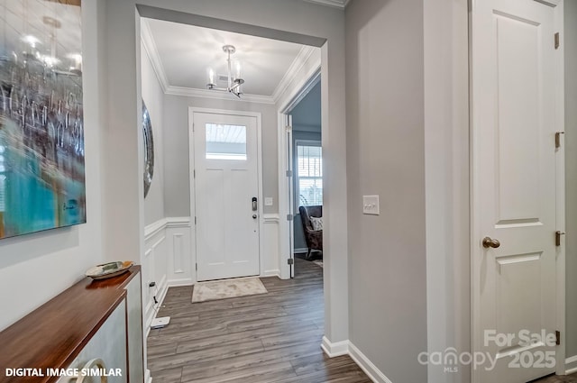 9945 Cask Way, Huntersville, NC 28078 - foyer featuring crown molding, a chandelier, wood finished floors, wainscoting, and a decorative wall