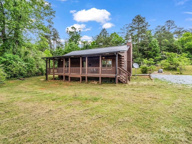 back of house with a lawn, a chimney, metal roof, log siding, and a deck
