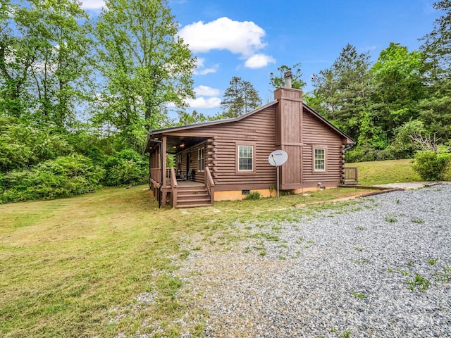 back of property featuring log siding, a lawn, and a chimney