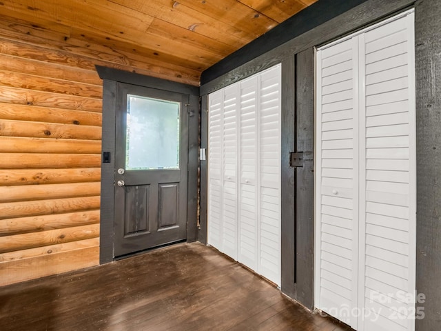 doorway to outside featuring rustic walls, dark wood finished floors, and wood ceiling
