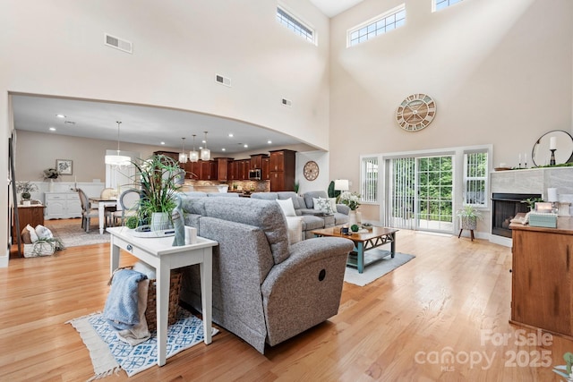 4616 Gold Finch Dr, Denver, NC 28037 - living area with a towering ceiling, light wood-style floors, a fireplace, arched walkways, and recessed lighting