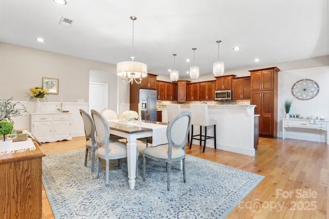 4616 Gold Finch Dr, Denver, NC 28037 - dining space featuring light wood finished floors, recessed lighting, a chandelier, and a wainscoted wall