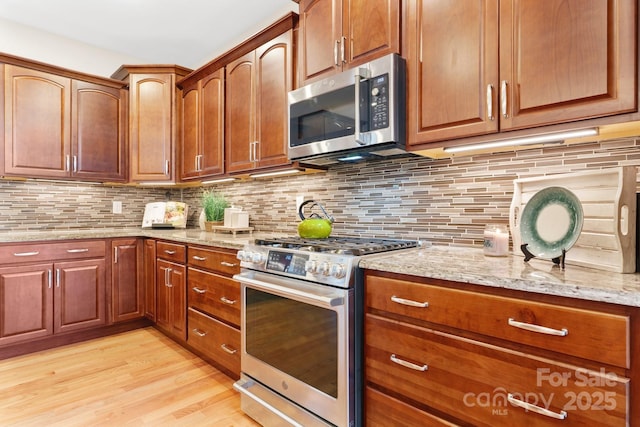 4616 Gold Finch Dr, Denver, NC 28037 - kitchen with appliances with stainless steel finishes, light wood-style flooring, light stone countertops, and backsplash