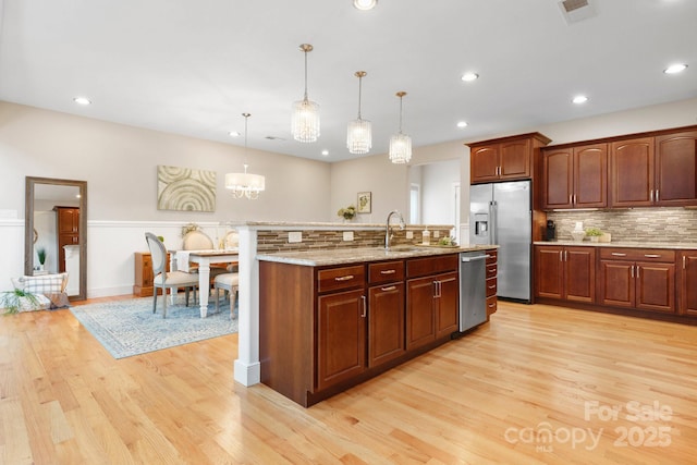 4616 Gold Finch Dr, Denver, NC 28037 - kitchen with appliances with stainless steel finishes, light wood-style flooring, tasteful backsplash, decorative light fixtures, and recessed lighting