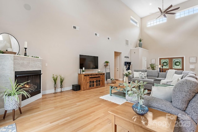 4616 Gold Finch Dr, Denver, NC 28037 - living room featuring wood finished floors, ceiling fan, a towering ceiling, and a tile fireplace