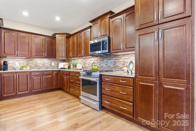 4616 Gold Finch Dr, Denver, NC 28037 - kitchen with stainless steel appliances, light wood finished floors, light stone counters, tasteful backsplash, and recessed lighting