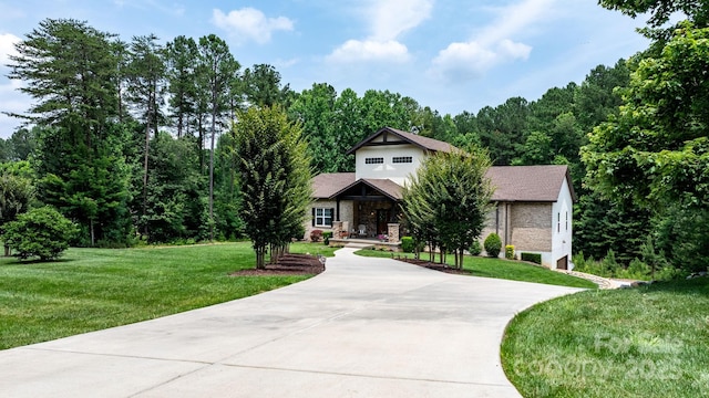 4616 Gold Finch Dr, Denver, NC 28037 - view of property hidden behind natural elements featuring driveway, a front lawn, stone siding, and a forest view