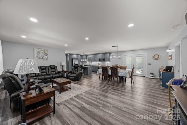 living room with recessed lighting, dark wood-type flooring, and french doors
