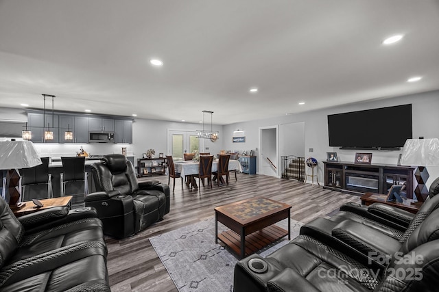 living area featuring recessed lighting, wood finished floors, and a chandelier