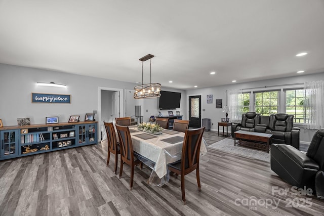 dining space featuring recessed lighting, wood finished floors, a chandelier, and baseboards