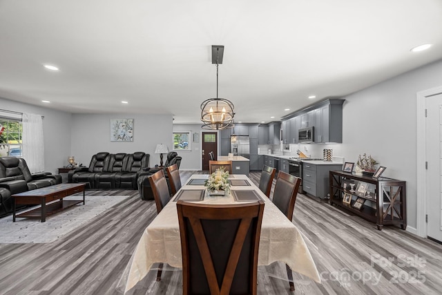 dining space featuring light wood finished floors, a chandelier, and recessed lighting