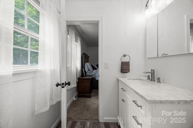 bathroom with wood finished floors, vanity, and baseboards