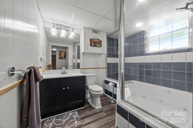 full bath with wood finished floors, toilet, vanity, and a combined bath / shower with jetted tub