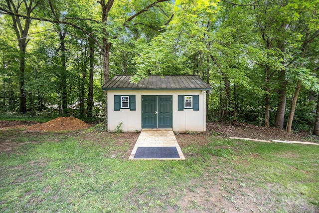 view of outbuilding with an outbuilding and a forest view