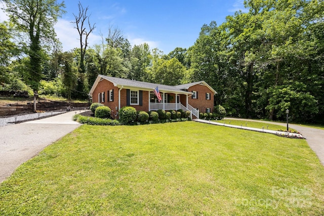 ranch-style house with a porch, brick siding, driveway, and a front yard
