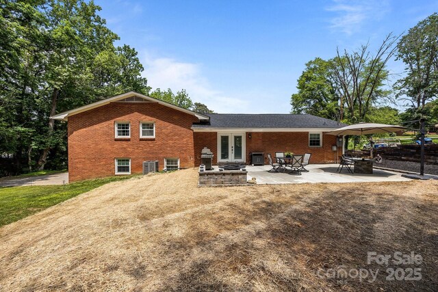 2076 Junction Rd, Mocksville, NC 27028 - back of property featuring french doors, brick siding, central air condition unit, and a patio area
