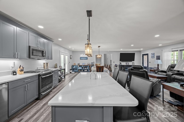 2076 Junction Rd, Mocksville, NC 27028 - kitchen with stainless steel appliances, gray cabinets, wood finished floors, open floor plan, and recessed lighting