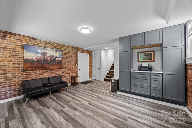 2076 Junction Rd, Mocksville, NC 27028 - living room with brick wall, light wood-style floors, stairway, and baseboards