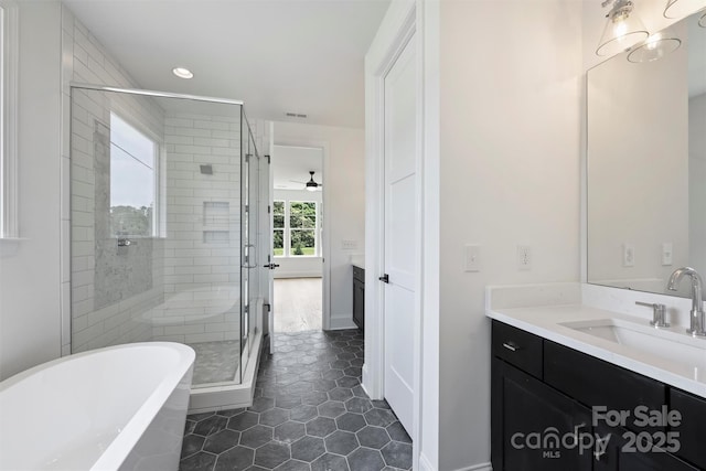 13605 Tranquil Day Dr, Matthews, NC 28105 - full bathroom featuring vanity, a freestanding tub, a stall shower, a ceiling fan, and recessed lighting