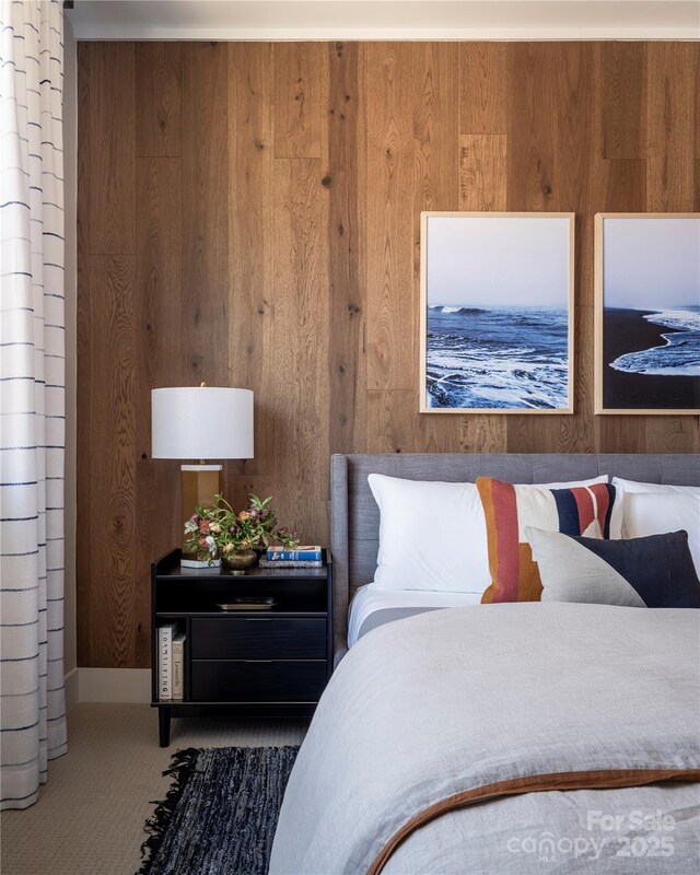bedroom featuring wood walls and carpet floors