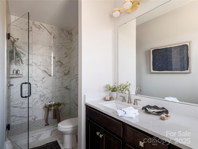 full bathroom featuring a marble finish shower, toilet, vanity, and marble finish flooring