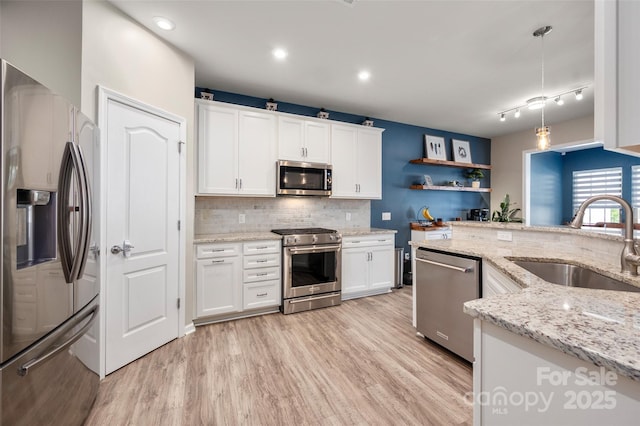5014 Forest Hills Pl, Fort Mill, SC 29707 - kitchen featuring appliances with stainless steel finishes, a sink, backsplash, light wood-style floors, and white cabinetry