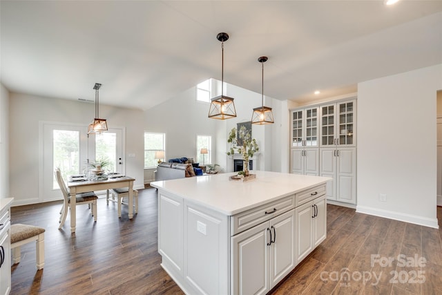 18011 Wilbanks Dr, Charlotte, NC 28278 - kitchen featuring dark wood-type flooring, light countertops, white cabinets, pendant lighting, and a kitchen island