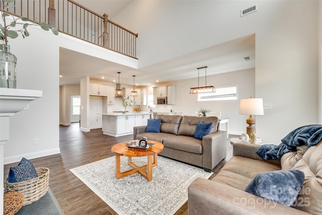 18011 Wilbanks Dr, Charlotte, NC 28278 - living room featuring dark wood-type flooring, recessed lighting, a high ceiling, and baseboards