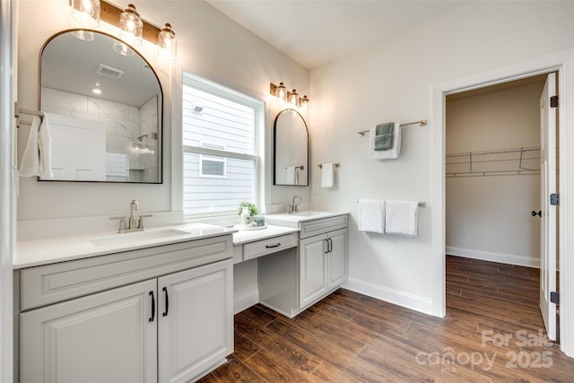 18011 Wilbanks Dr, Charlotte, NC 28278 - full bathroom featuring vanity, wood finished floors, a tile shower, baseboards, and a walk in closet