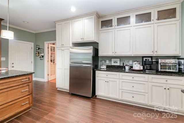 408 Idlewood Dr, Kannapolis, NC 28083 - kitchen with freestanding refrigerator, crown molding, dark wood-style flooring, dark stone countertops, and glass insert cabinets