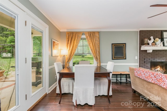 408 Idlewood Dr, Kannapolis, NC 28083 - dining room featuring dark wood-style flooring, crown molding, a ceiling fan, a brick fireplace, and baseboards