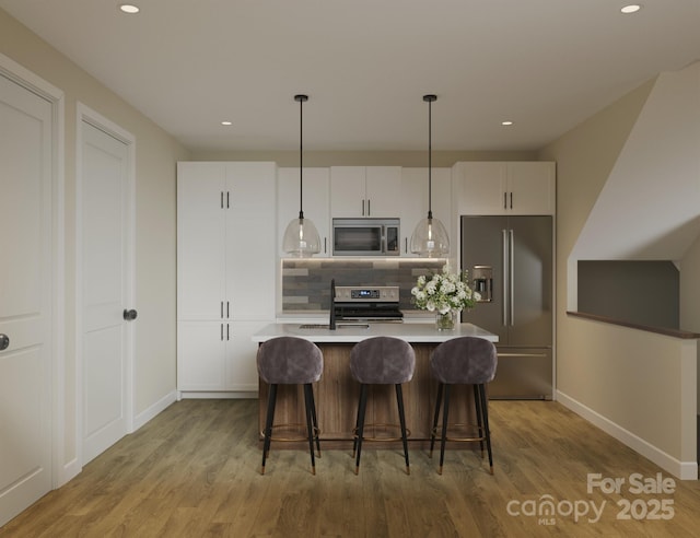 kitchen with stainless steel appliances, decorative backsplash, light wood-style floors, baseboards, and white cabinets