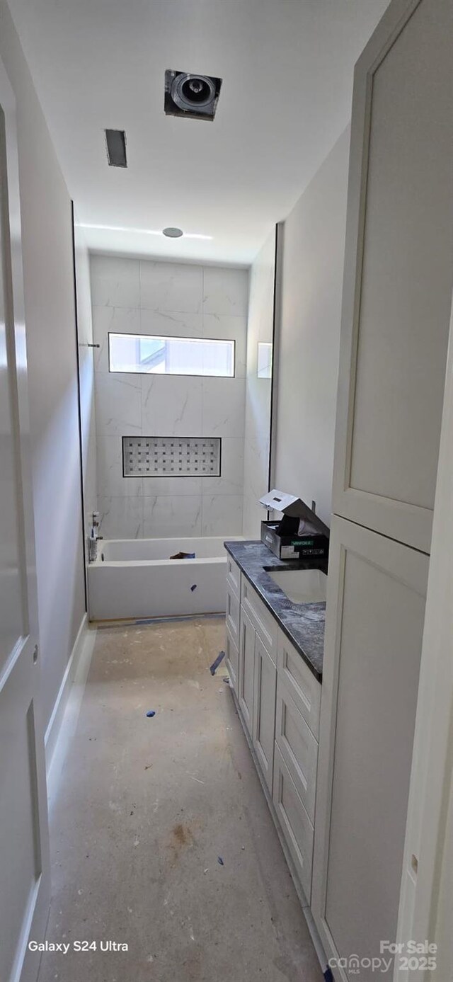 bathroom featuring vanity, bathtub / shower combination, and concrete floors
