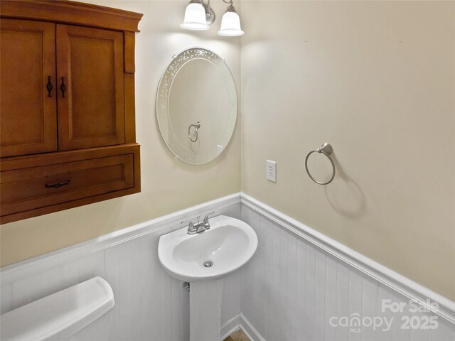 903 Furman Ct, Fort Mill, SC 29708 - half bathroom with a wainscoted wall, a sink, toilet, and a decorative wall