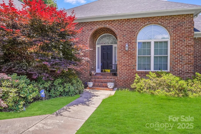 1337 Braeburn Rd NW, Concord, NC 28027 - doorway to property featuring a lawn, brick siding, and a shingled roof