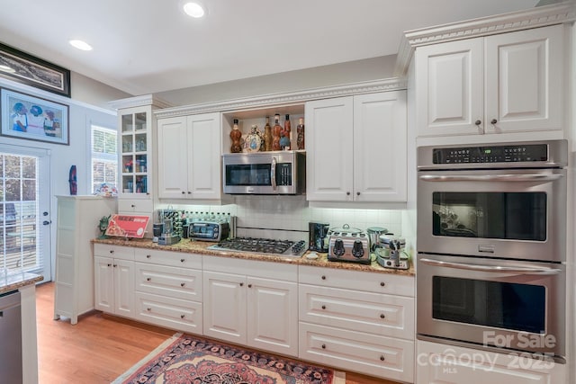 1337 Braeburn Rd NW, Concord, NC 28027 - kitchen featuring stainless steel appliances, decorative backsplash, light wood-style floors, light stone countertops, and white cabinetry