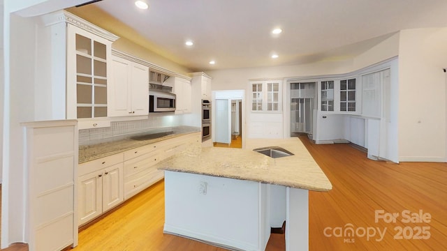 1337 Braeburn Rd NW, Concord, NC 28027 - kitchen with decorative backsplash, glass insert cabinets, stainless steel appliances, recessed lighting, and light wood-style flooring