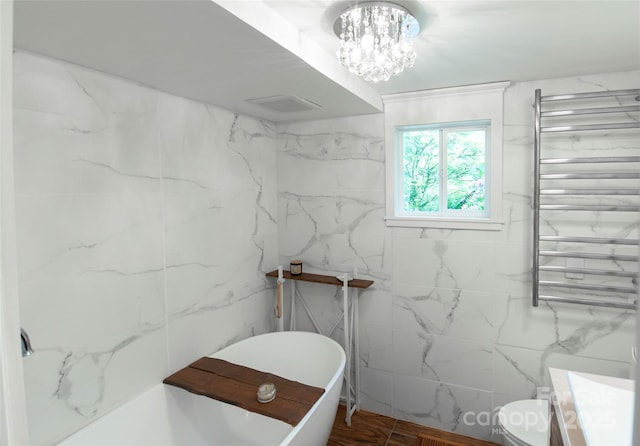 37 Geneva Cir Unit 1/2, Franklin, NC 28734 - bathroom with radiator heating unit, a towel warming rack, a soaking tub, vanity, and tile walls