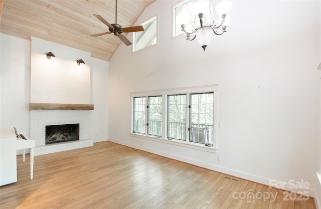 37 Geneva Cir Unit 1/2, Franklin, NC 28734 - unfurnished living room featuring high vaulted ceiling, wood-type flooring, ceiling fan, a brick fireplace, and a chandelier