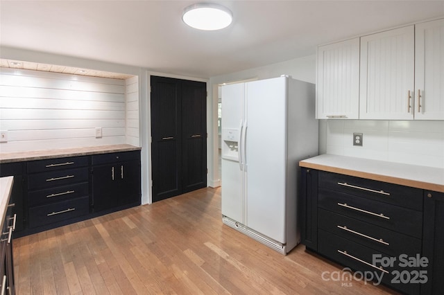 37 Geneva Cir Unit 1/2, Franklin, NC 28734 - kitchen with white fridge with ice dispenser, dark cabinetry, white cabinets, light wood-style flooring, and light countertops