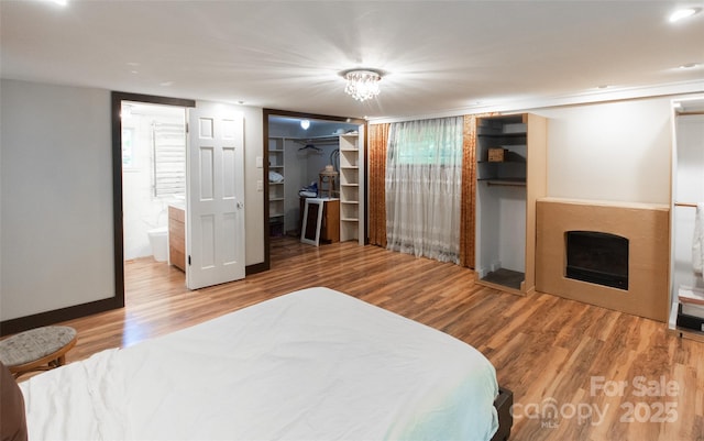 37 Geneva Cir Unit 1/2, Franklin, NC 28734 - bedroom featuring wood finished floors, a fireplace, and connected bathroom