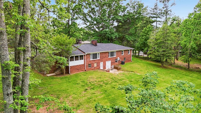 200 Woodside Dr, Morganton, NC 28655 - back of property with brick siding, a chimney, a sunroom, and a lawn