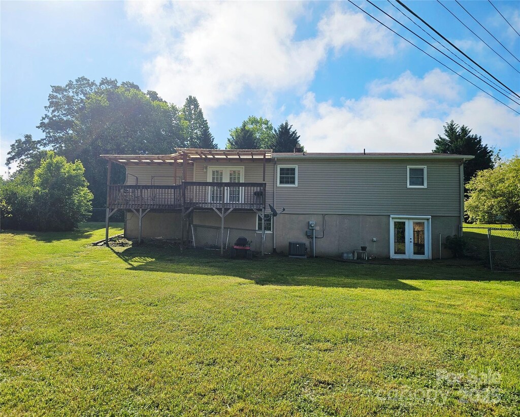 rear view of house featuring french doors, a yard, a pergola, and a wooden deck