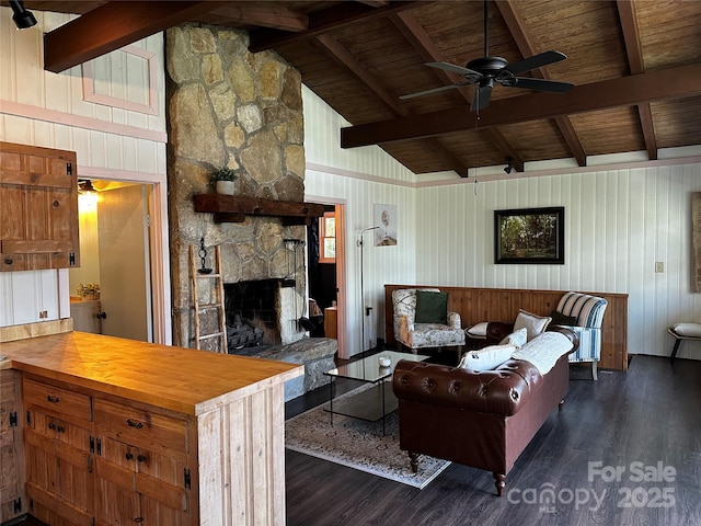 living area with wood ceiling, wood finished floors, a ceiling fan, wood walls, and a stone fireplace