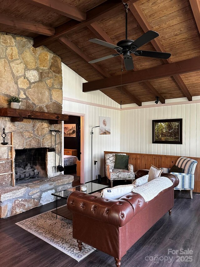 living area featuring wood ceiling, wood finished floors, ceiling fan, a stone fireplace, and wood walls