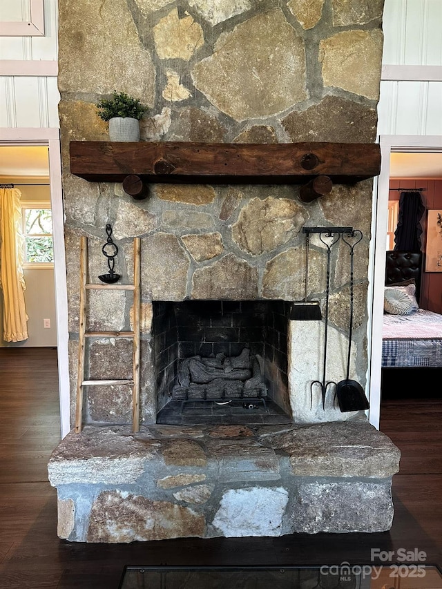 detailed view of wood finished floors and a stone fireplace