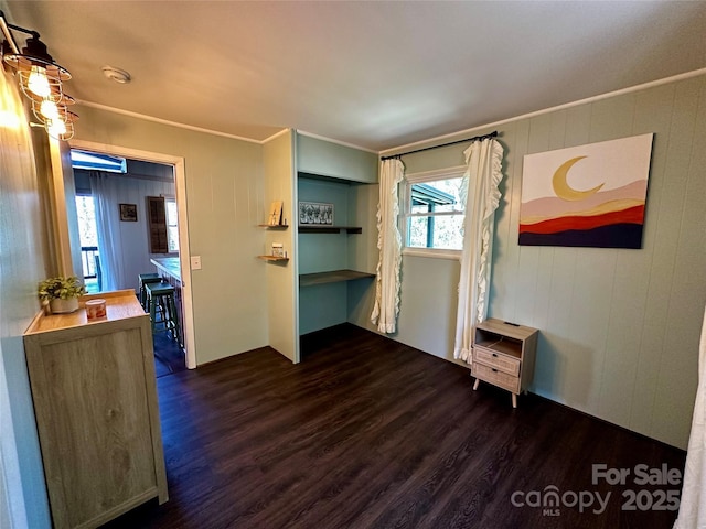 empty room with dark wood-style flooring and ornamental molding