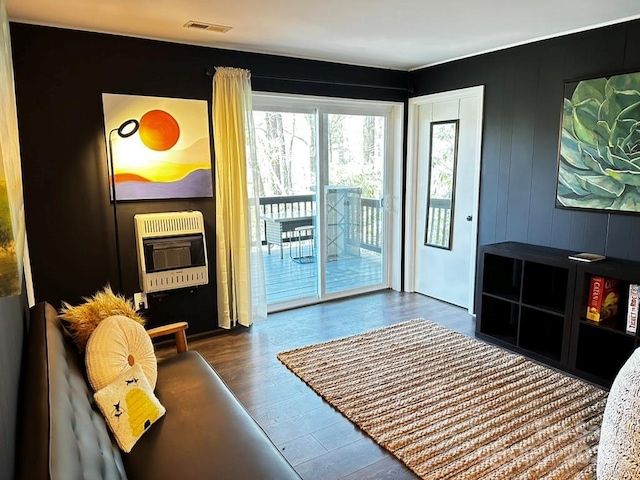 doorway to outside with heating unit and wood finished floors